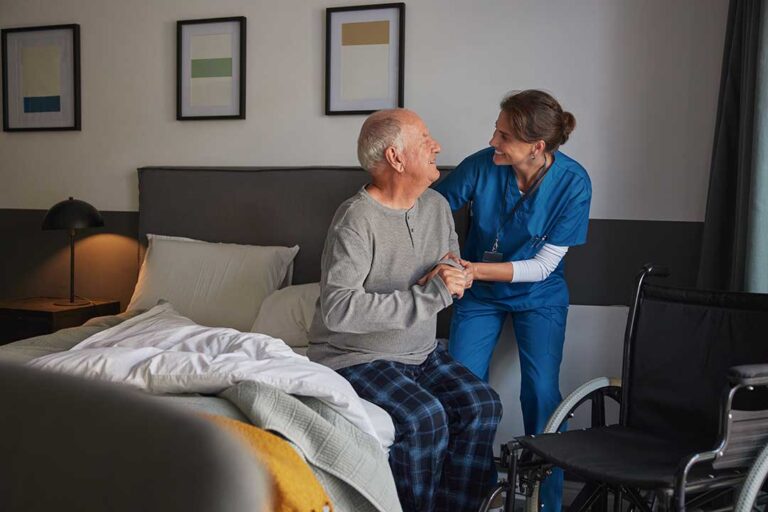 Caregiver and older adult reviewing a weekly care plan together at a kitchen table.
