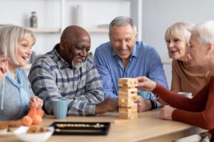 Older adult residents share a meal and conversation in a bright assisted living dining room.